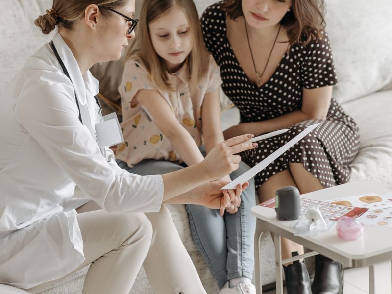 Doctora orientando a una madre y su hija - seguro médico para familias en Florida y Texas